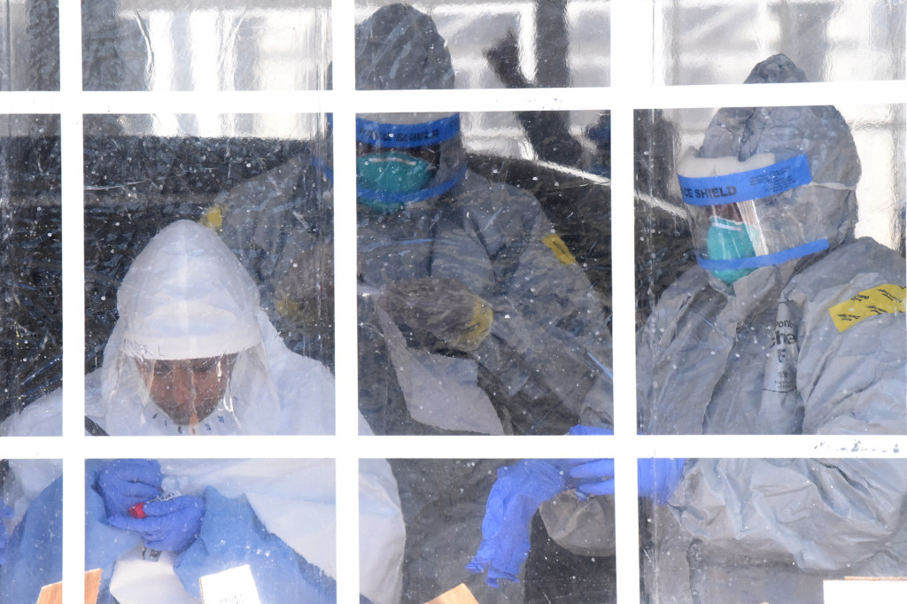 A medical professional, supported by New York Army National Guard members, collects swabs to test for coronavirus disease (COVID-19) infections in New Rochelle