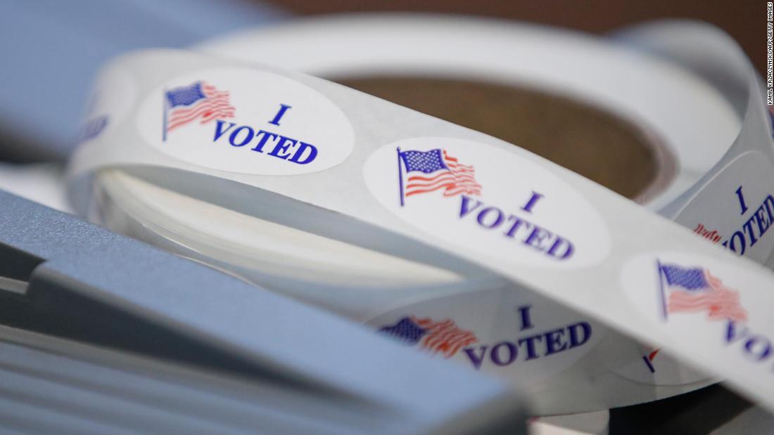 Key swing state Wisconsin opens in-person voting as Covid
cases hit record spike 1