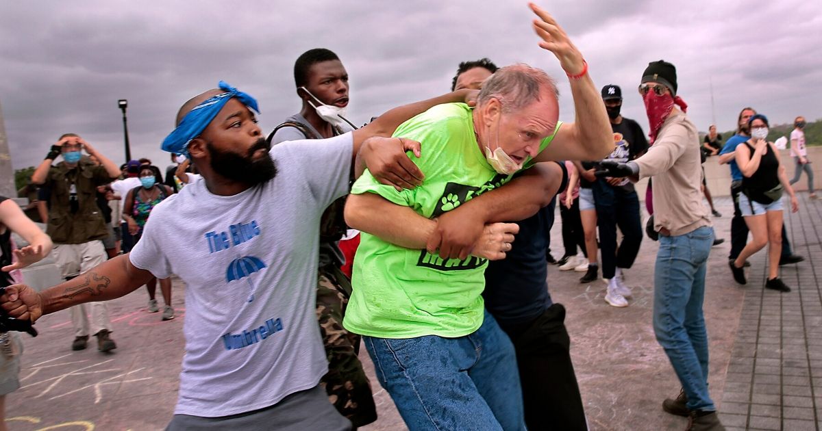 St. Louis Protesters Clash with Catholics in Fight To Tear
Down Statue of City’s Namesake 1