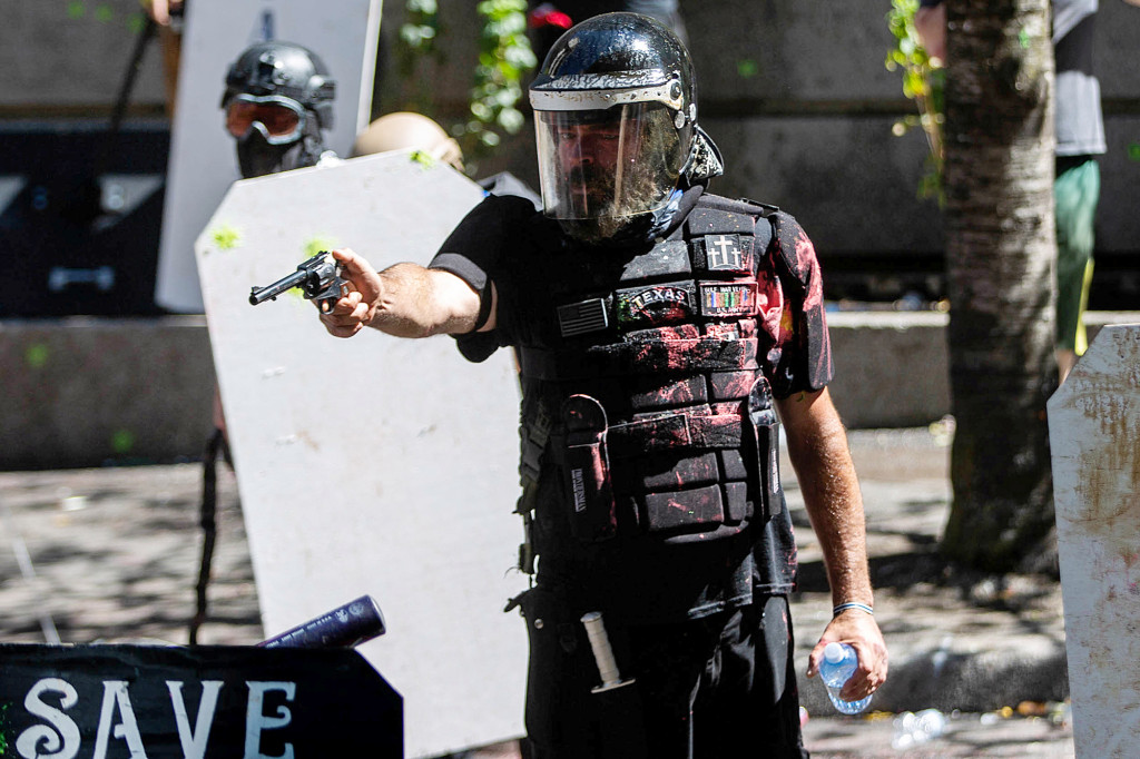 Portland cops stand by as groups of protesters clash with
guns, smoke bombs 1