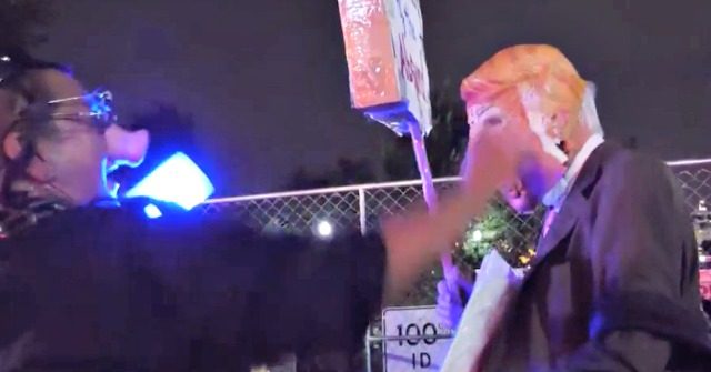 Watch: Protesters in Pig Masks and Police Uniforms Force
'Trump' to Take a Knee 1
