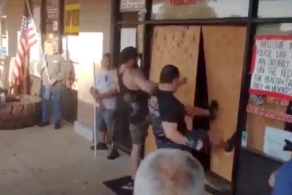 New Jersey gym owners defy COVID-19 lockdown again, kick
down boarded-up door 1