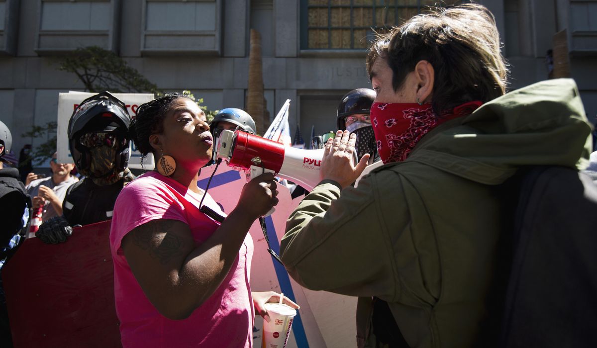 Fire set at police precinct as protesters gather in
Portland 1