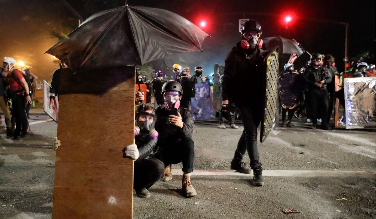 Portland protesters use new, old tactics against
police 1