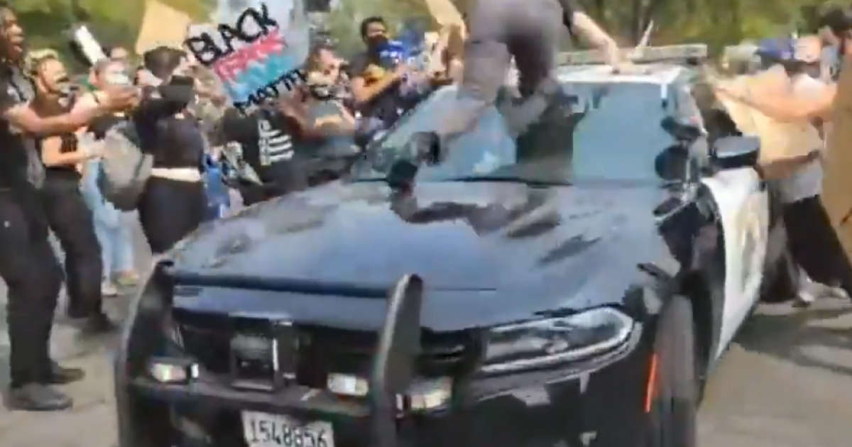 Black Lives Matter Rioter Who Attempts to Storm and Climb
Police Car in Sacramento Is Sent Flying 1