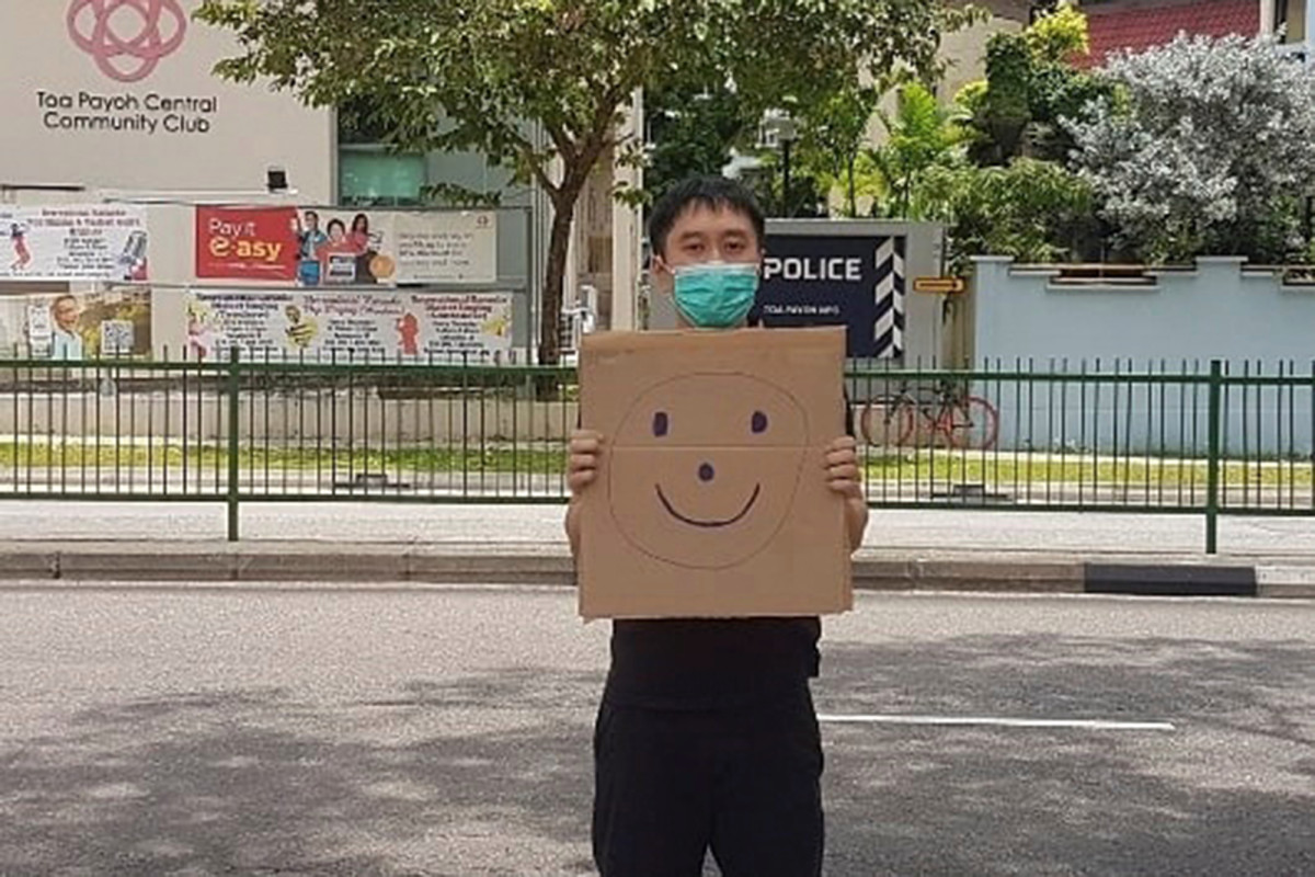 Singapore activist faces fine over one-man smiley face sign
protest 1