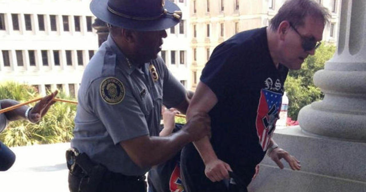 Black police officer helps demonstrator at KKK rally 1